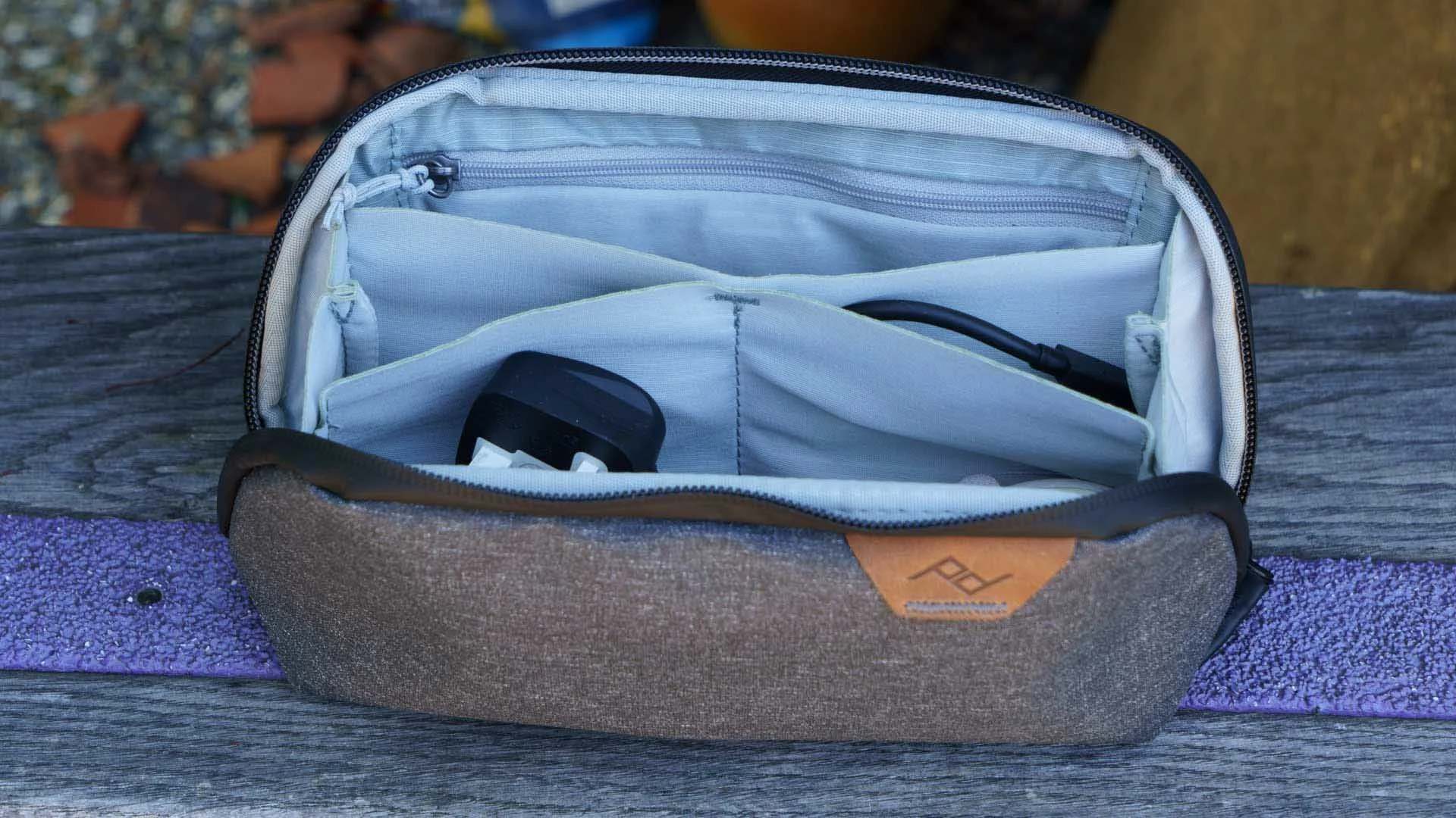 The Peak Design Small Tech Pouch opens like a clamshell to reveal its contents organised in the compartments.
