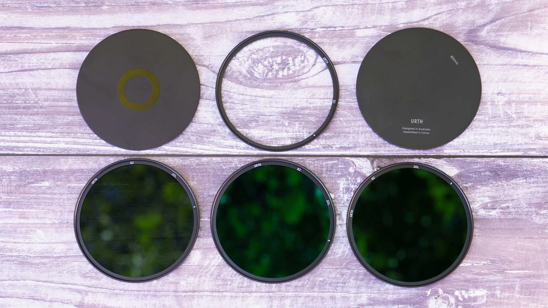  The Urth Magnetic ND Selects Filter Kit Plus+, showing from left to right,  top: end cap 1, magnetic adapter ring, end cap 2,  bottom: ND 8, ND 64, ND 1000. 