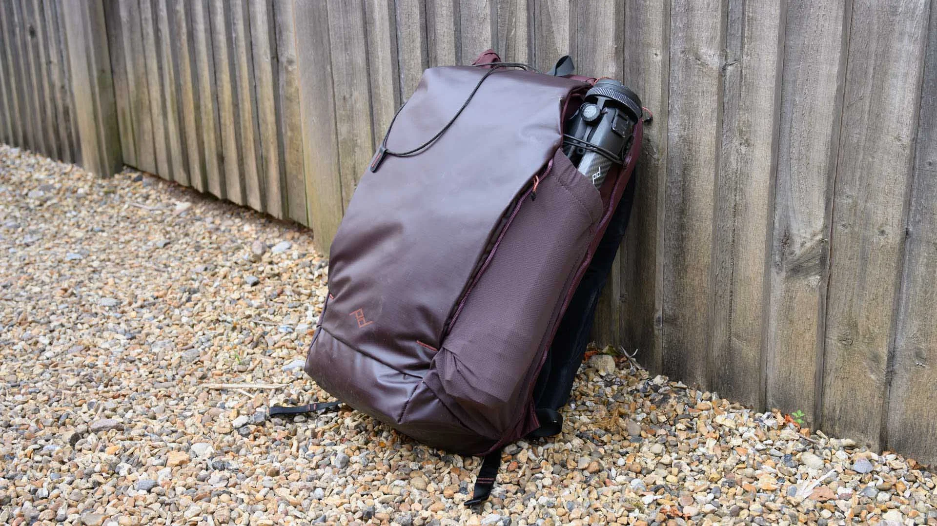 The Peak Design Outdoor Backpack 25L (shown here in the Eclipse colour) has a wipe-clean front that houses two flat side pockets and a 'kangaroo pouch'. The top flap extension of the front covers the roll-top of the main compartment.