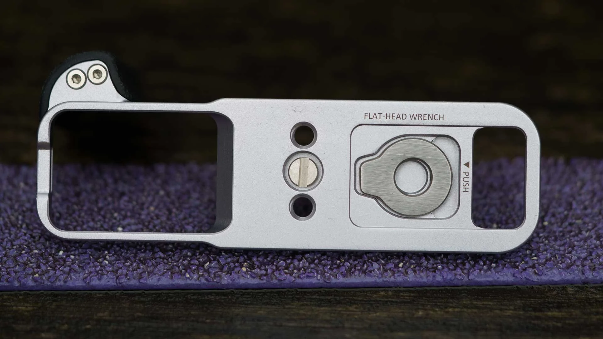  The underside of the SmallRig L-Shaped Mount Plate with Silicone Handle for the Fujifilm X-E5, showing the flat-head screwdriver (aka wrench) that’s held magnetically in its bespoke recess. The large cut-out on the left gives access to the camera’s battery port and memory card slot. 