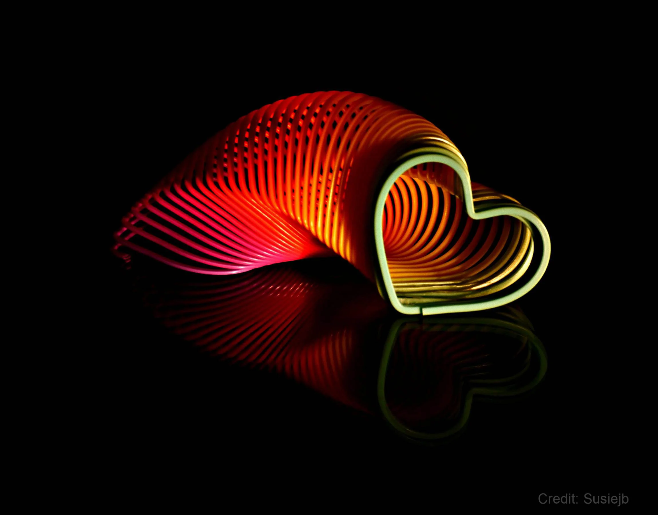 Colorful heart-shaped slinky toy on black background