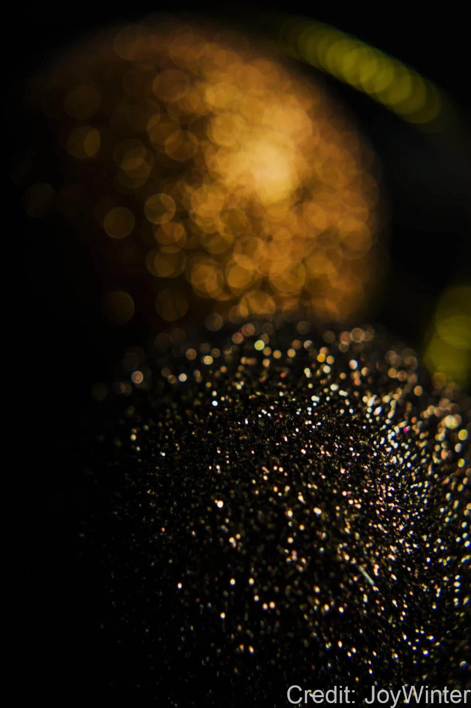 Abstract close-up of sparkling black and gold bokeh.