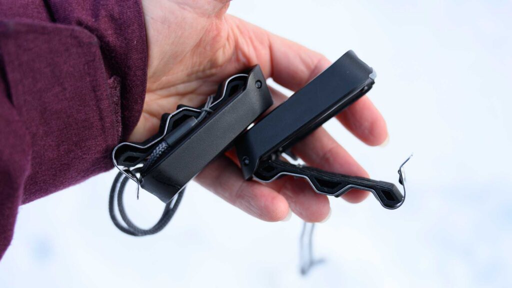 Side profile of two Carv sensors in a hand, emphasizing their slim shape and clip mechanism.