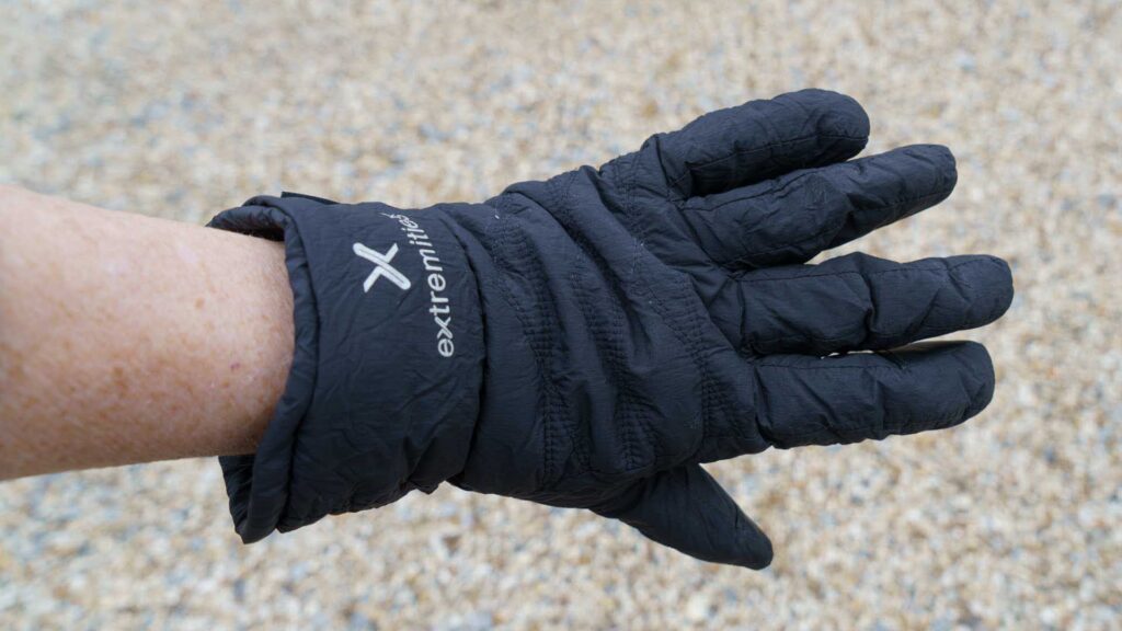 Back view of a black glove on a hand, showing Extremities branding and gathered wrist cuff.