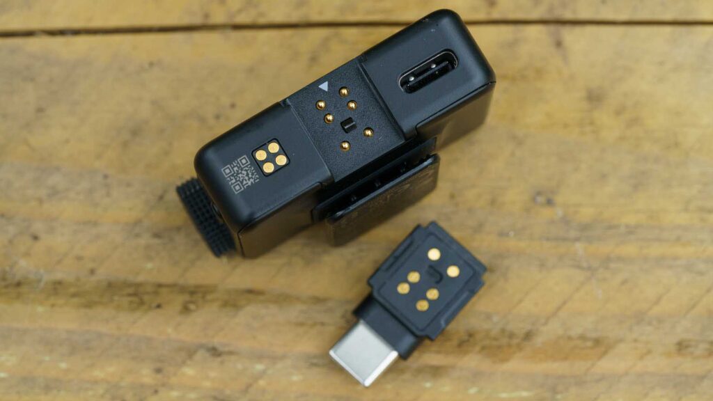 Underside of receiver displaying USB-C port, contact pins, and mounting clip.