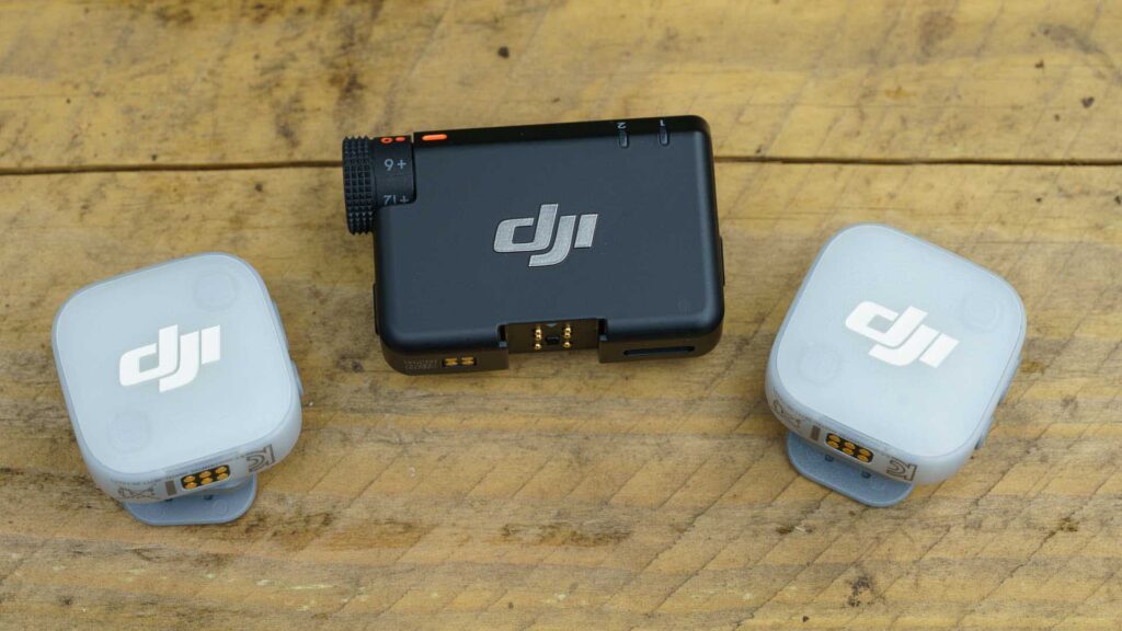 Two transmitters placed beside receiver, all showing DJI branding and contact pins.