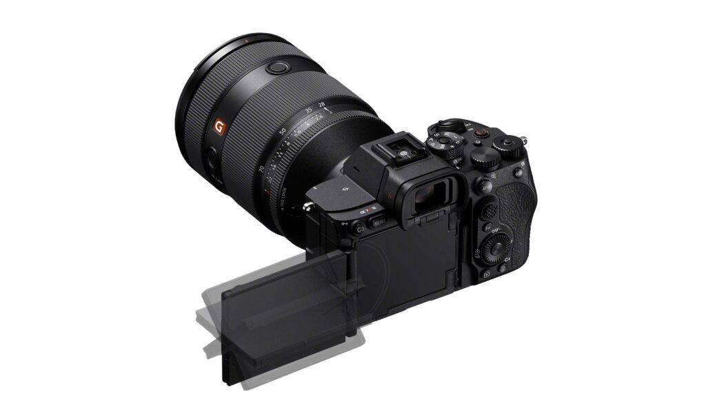 Sony A7R VI mirrorless camera shown from a rear angle with a large attached lens and the rear LCD screen tilted outward against a light gray background.