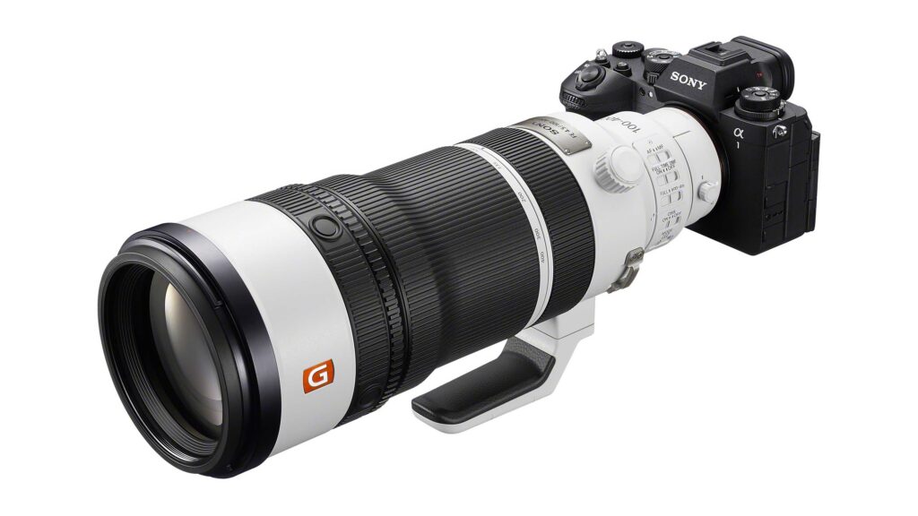 White Sony FE 100–400mm F4.5 GM OSS telephoto zoom lens mounted on a Sony Alpha mirrorless camera body, shown at an angled view against a light gray background.