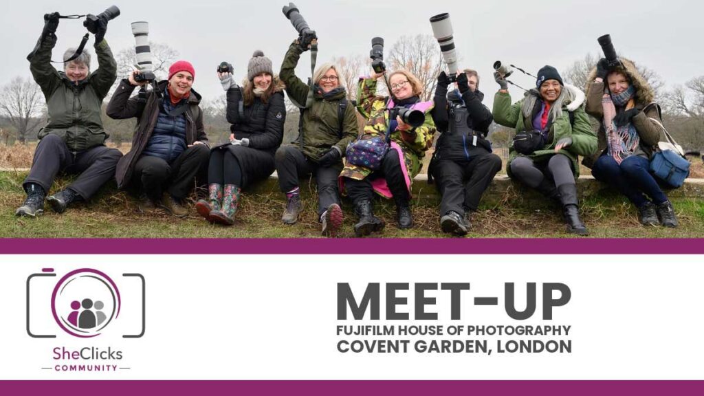 Group of photographers outdoors holding cameras with long lenses, above text and logos for SheClicks Community and “Meet-Up – Fujifilm House of Photography, Covent Garden, London.”