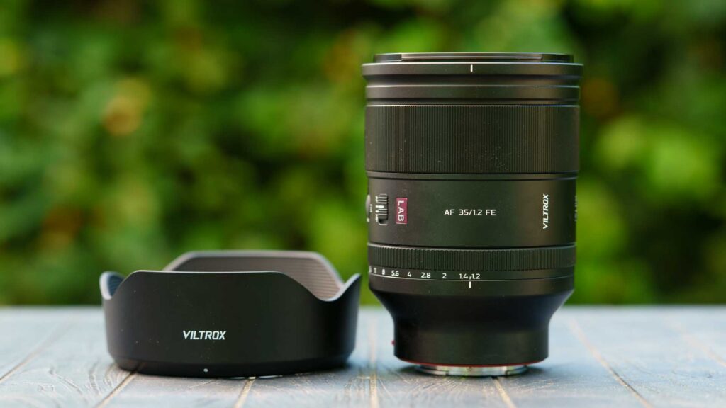 Viltrox AF 35mm F1.2 LAB FE lens standing beside its large petal-shaped lens hood.