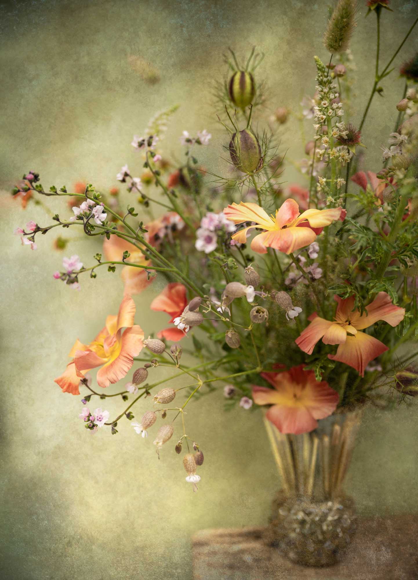 Loose arrangement of peach, pink and white flowers and seed heads in a textured vase, photographed with a soft, painterly finish.
