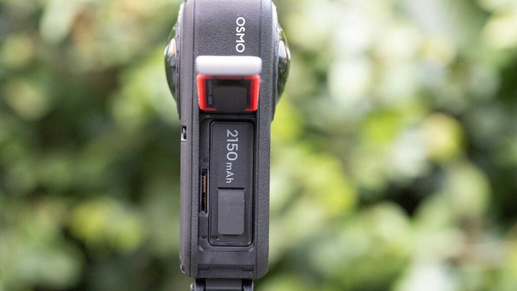 DJI Osmo 360 II with its side compartment open, showing a removable battery marked 2150mAh.