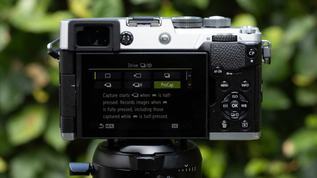 Rear screen of the OM System PEN showing the Drive menu with ProCap highlighted and an explanation of Pro Capture shooting.