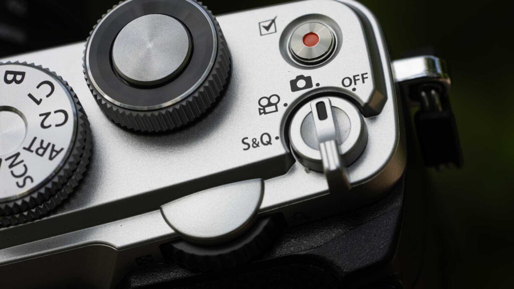 Close-up of the PEN’s silver top plate showing the shutter button, red video record button and selector for stills, video, S&Q and Off.