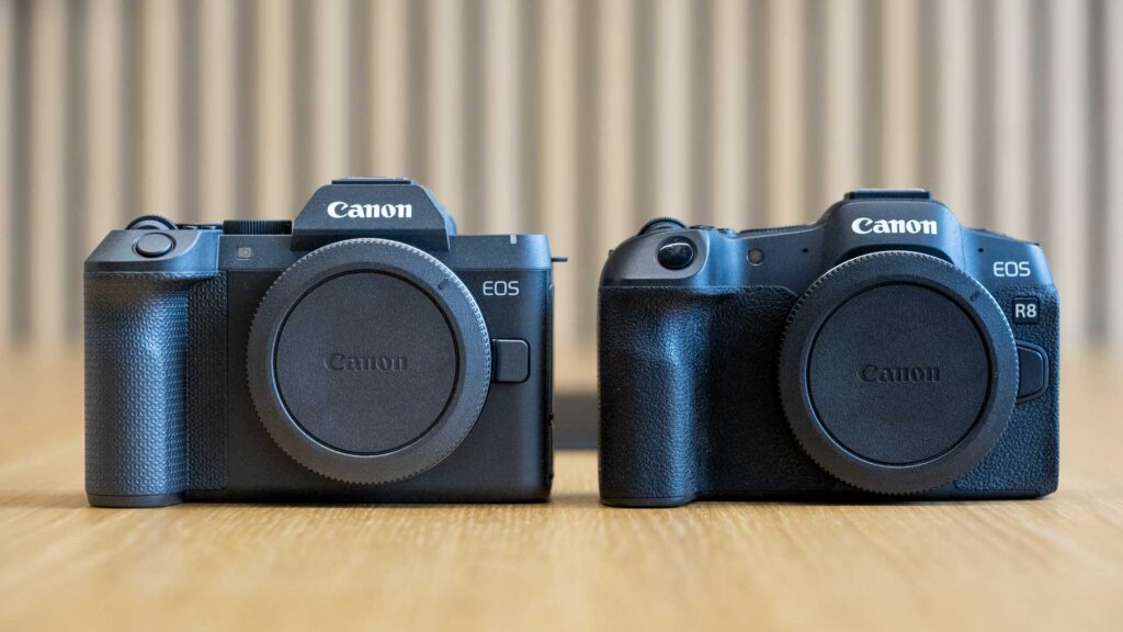 Front comparison of the Canon EOS R8 II on the left and EOS R8 on the right, both with body caps fitted, showing differences in body shape and grip design.