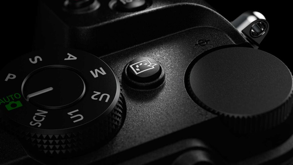 Close-up of the Nikon Z5IIC’s Picture Control button beside the mode dial on the top plate.