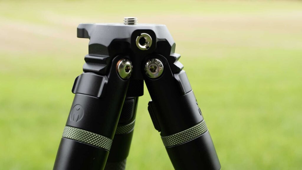 Close view of a tripod canopy, its mounting screw and two folded carbon-fibre legs.