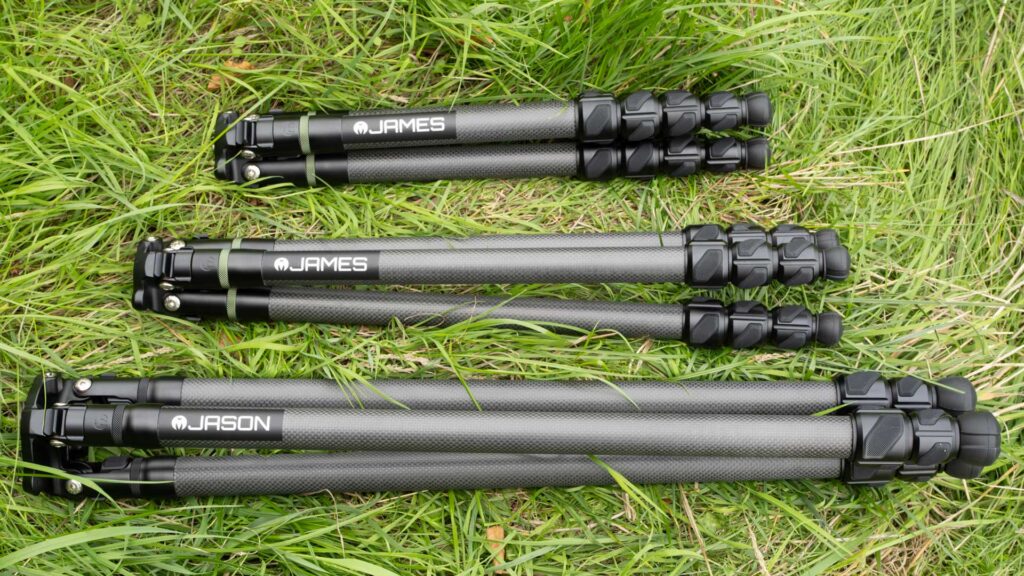 Two folded James tripods and a longer folded Jason tripod laid side by side on grass.